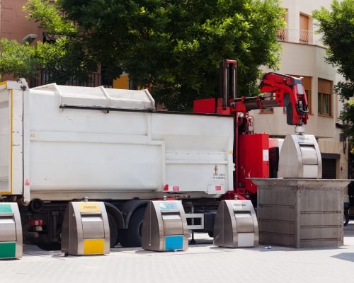 Recycling truck picking up bin at city street. Spain